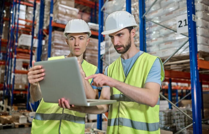 Two maintenance workers using a laptop